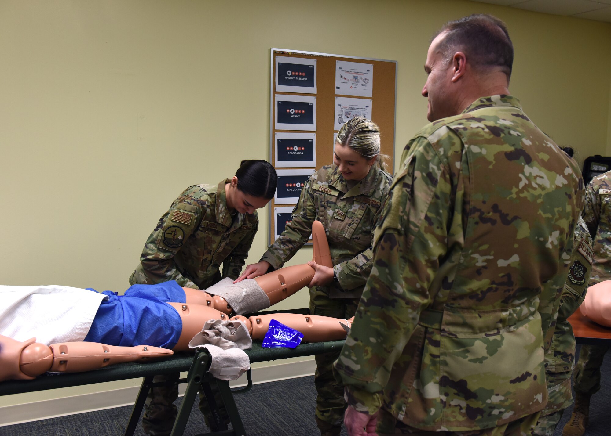 U.S. Air Force Maj. Gen. Thad Bibb, 18th Air Force commander, observes two 62nd Medical Squadron Airmen as they demonstrate first aid procedures at Joint Base Lewis-McChord, Washington, March 15, 2022. Bibb and U.S. Air Force Chief Master Sgt. Chad Bickley, 18th AF command chief, visited 62nd AW units and recognized several of the wing’s outstanding performers during their time. (U.S. Air Force photo/Senior Airman Zoe Thacker)