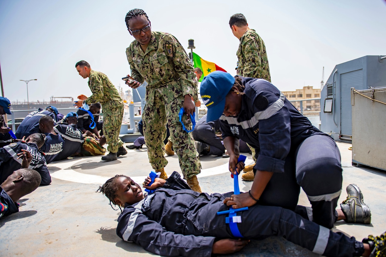U.S. sailors observe Senegalese sailors during a medical training aboard a ship.