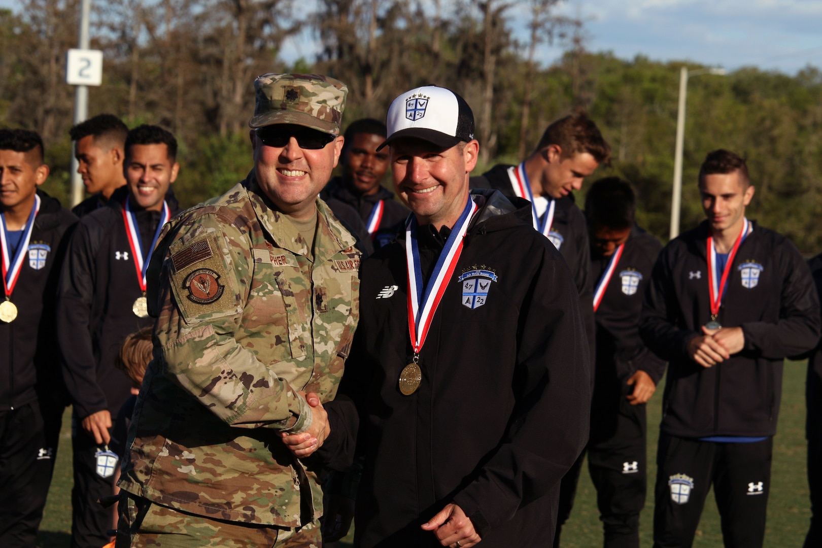 Air Force head coach Lt Col Jeremiah Kirschman of Fairchild Air Force Base, Wash. with MacDill Air Force Base Force Squadron Support, Lt. Col Mike Lupher celebrating team gold, as Air Force goes undefeated in the 2022 Armed Forces Men’s Soccer Championship hosted by MacDill Air Force Base in Tampa, Florida from March 6-12.  The best players from the Army, Marine Corps, Navy and Air Force (with Space Force players) compete for gold.  (Photo by Ms. Arianna Dinote, Department of Defense Photo - Released)