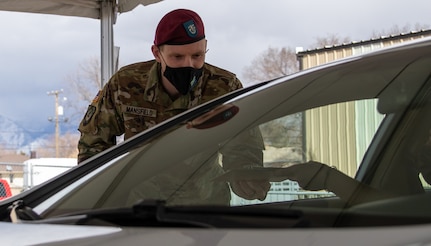 A Soldier with the Utah National Guard prepares a patient to receive a COVID-19 vaccination