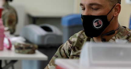 An Airman administers a vaccination.