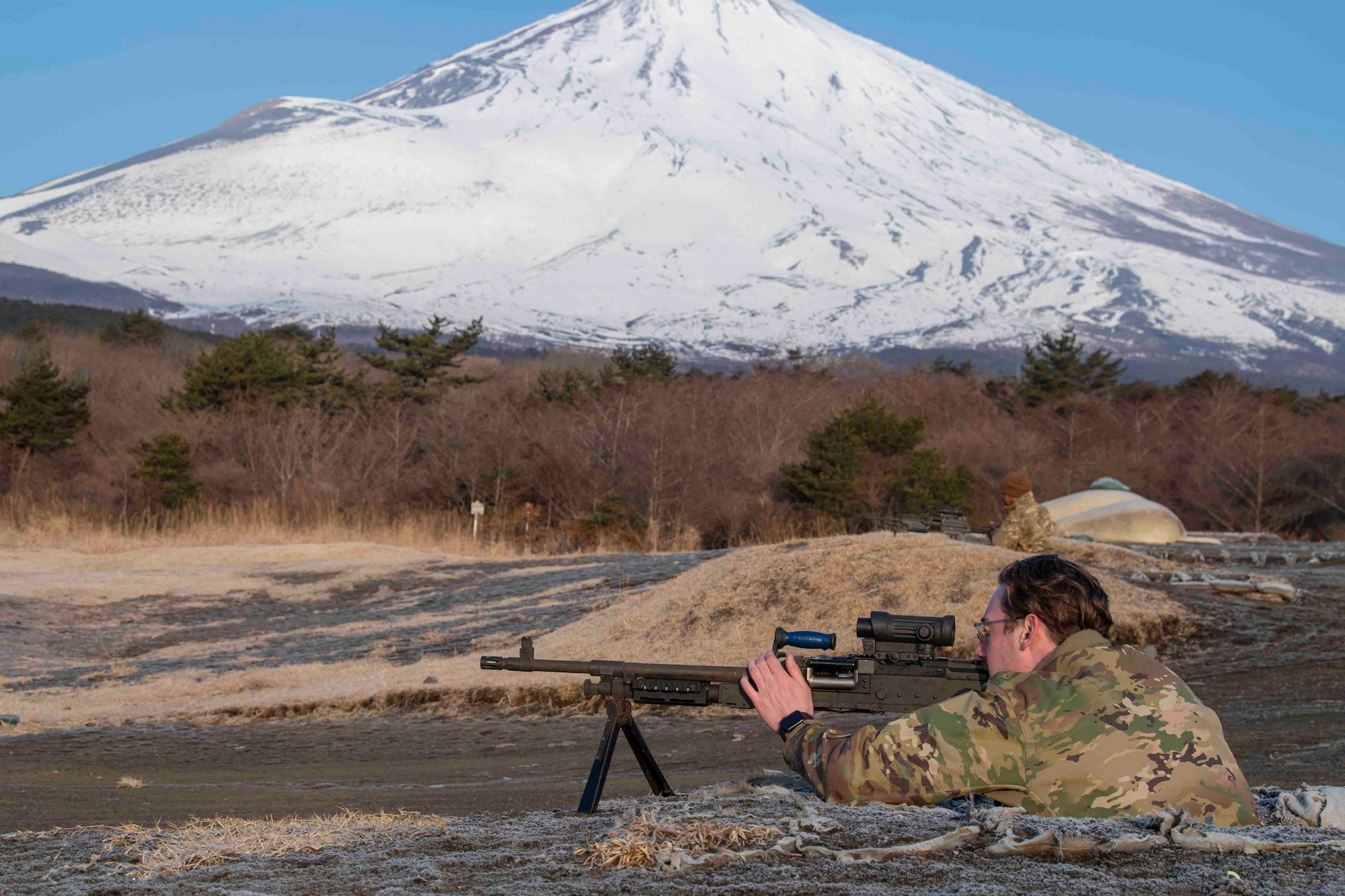 Airman 1st Class Derek Zickafoose, 374th Security Forces Squadron patrolman, checks an M240 light machine gun before providing it to students during an M240 and M249 machine guns qualification at Combined Arms Training Center Camp Fuji, Japan, March 10, 2022.