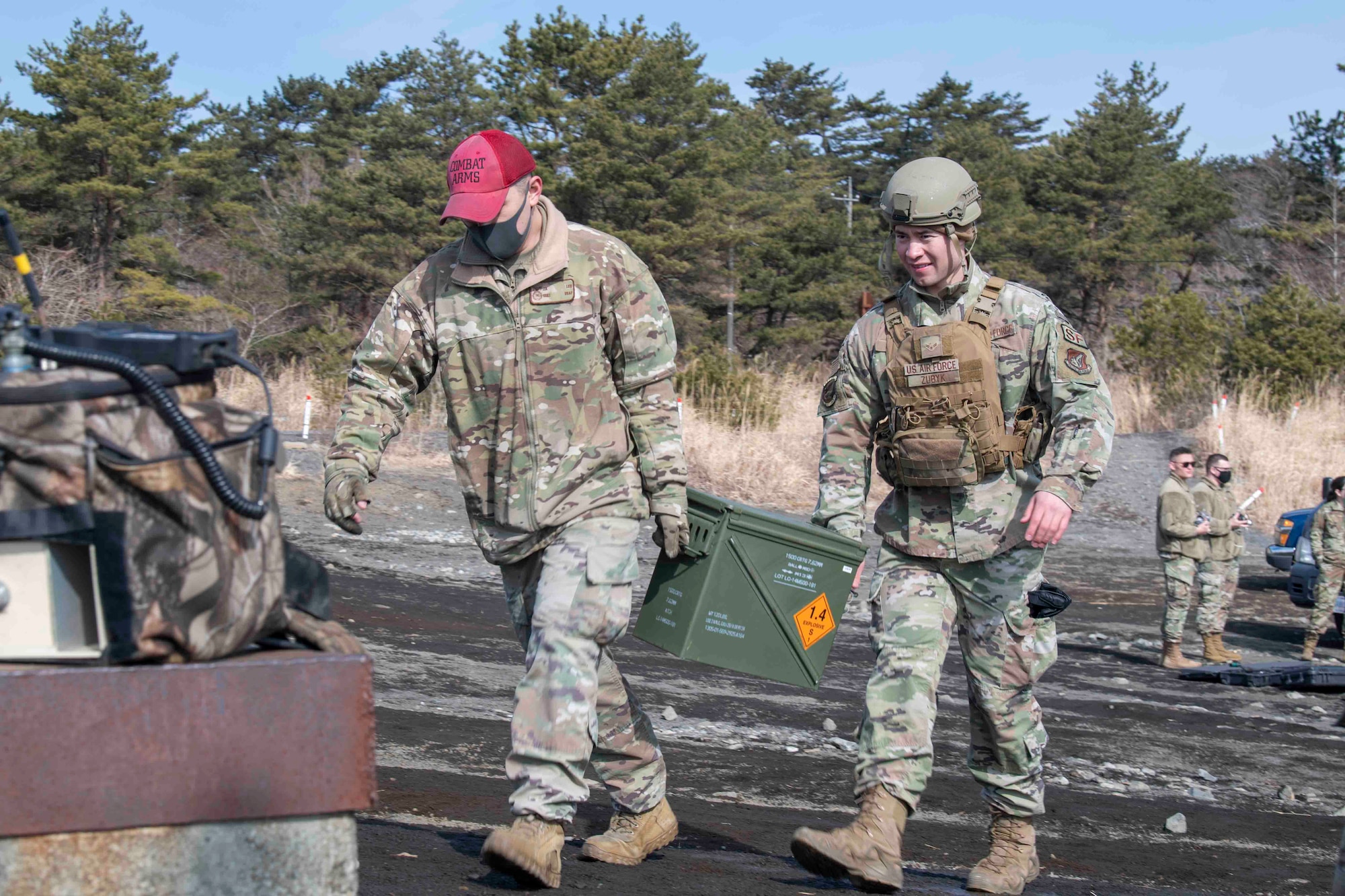 Tech Sgt. Ja Lee, 374th Security Forces Squadron combat arms training and maintenance instructor (left), and Airman 1st Class Cylas Zubyk, 374th SFS patrolman (right), carry ammo to the weapons set up prior to an M240 and M249 machine guns qualification at Combined Arms Training Center Camp Fuji, Japan, March 10, 2022.