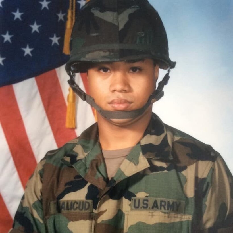Portrait of Command Sgt. Major Walter A. Tagalicud when he was a U.S. Army Pvt. in front of a U.S. flag.