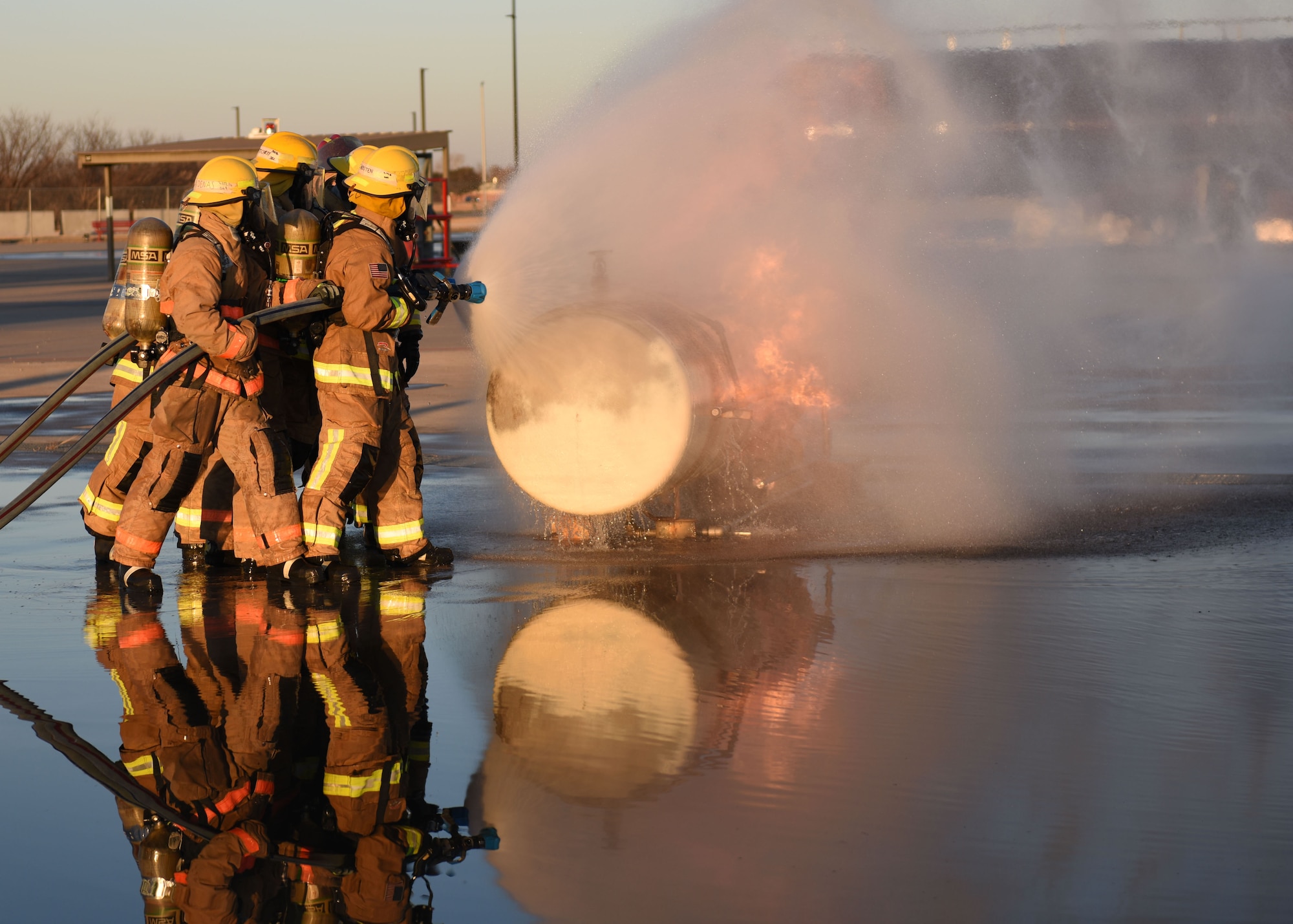 Students assigned to the 312th Training Squadron extinguish a cylinder fire at the Louis F. Garland Department of Defense Fire Academy, Goodfellow Air Force Base, March 9, 2022. The simulator teaches students how to react to a liquid evaporation and expansion explosion. (U.S. Air Force photo by Airman 1st Class Sarah Williams)