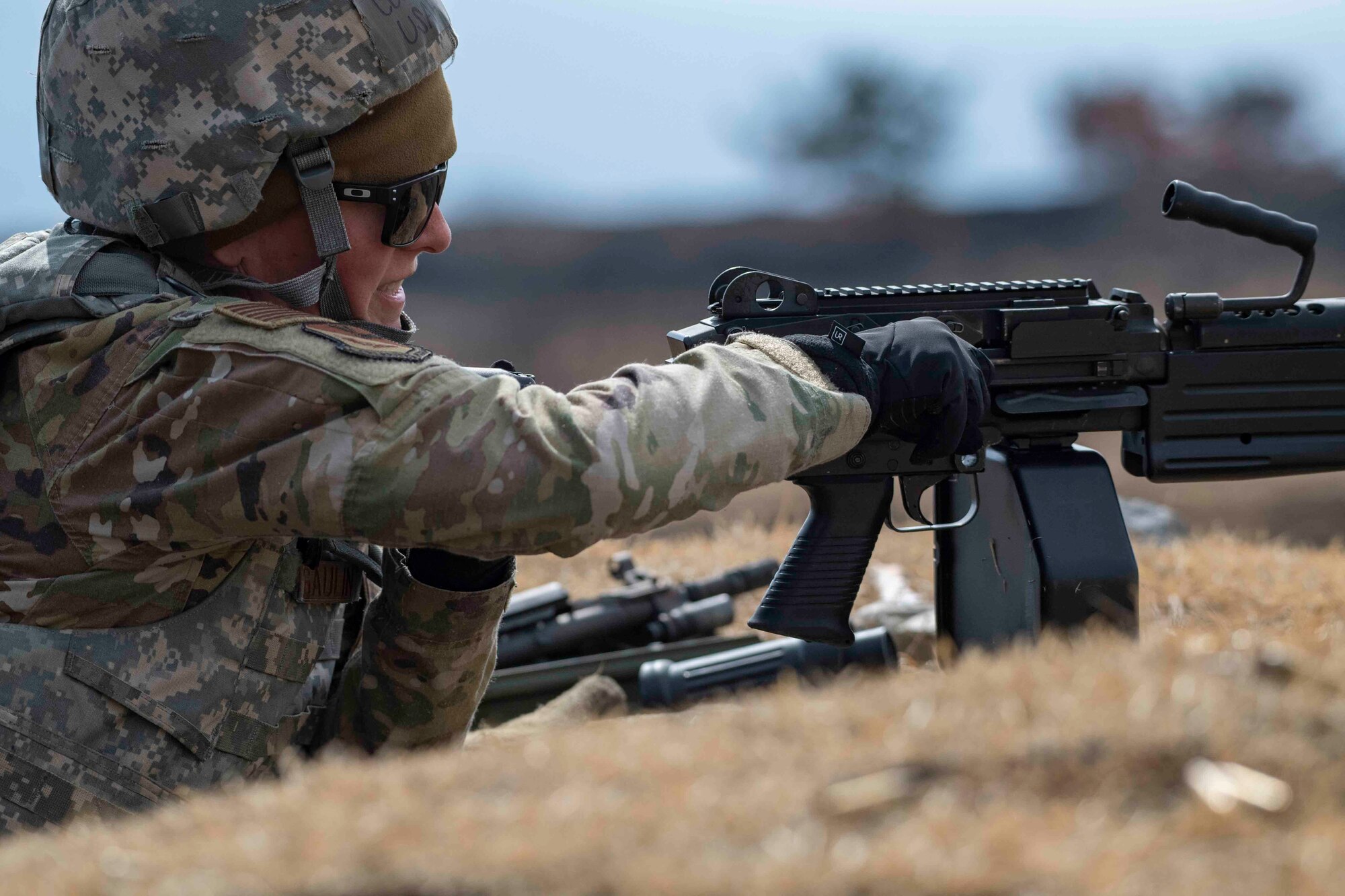 Col. Julie Gaulin, 374th Airlift Wing vice commander, pulls the cocking handle of an M249 light machine gun at Combined Arms Training Center Camp Fuji, Japan, March 10, 2022.