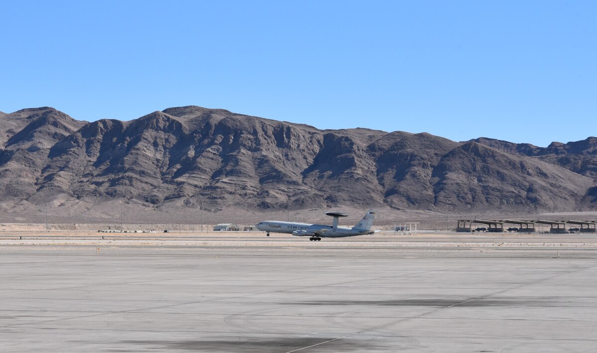 Airplane taking off with mountains in background