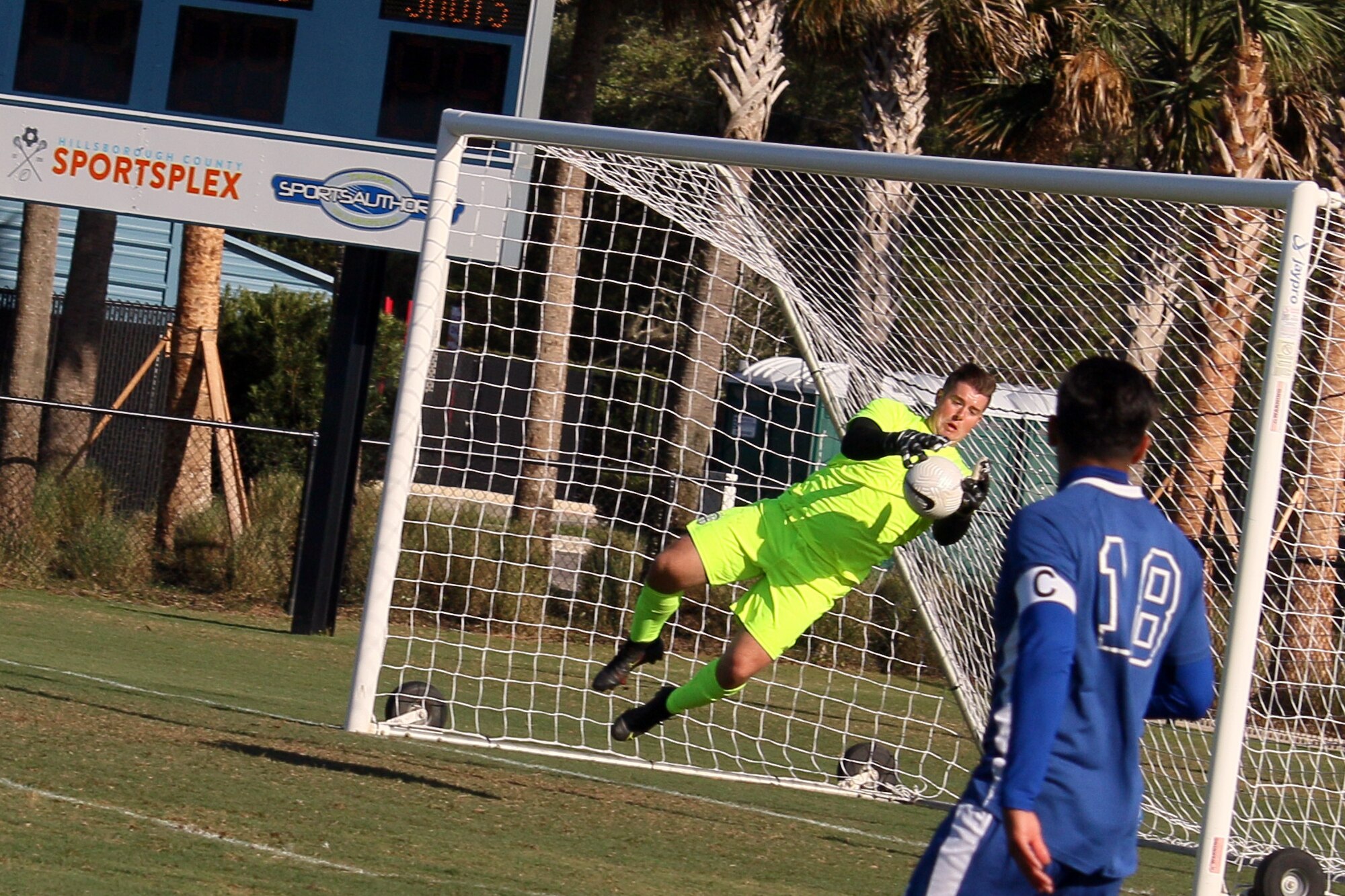 Air Force goalkeeper Senior Airman Gavin Bryant of Joint Base Langley-Eustis, Vir. dives for the save against Navy during the championship match of the 2022 Armed Forces Men’s Soccer Championship hosted by MacDill Air Force Base in Tampa, Florida from March 6-12.  The best players from the Army, Marine Corps, Navy and Air Force (with Space Force players) compete for gold.  (Photo by Ms. Arianna Dinote, Department of Defense Photo - Released)