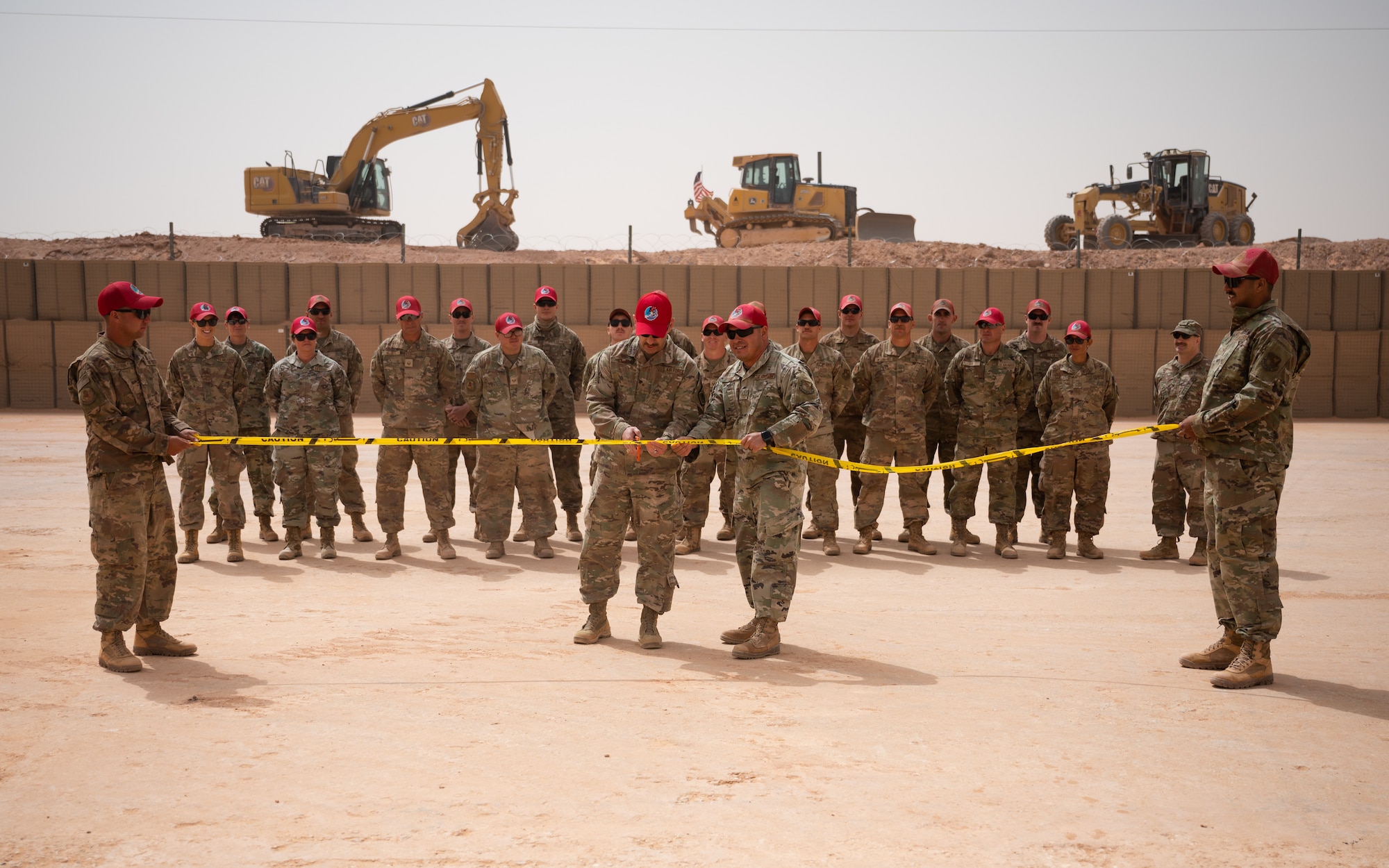 Brig. Gen. Robert Davis, 378th Air Expeditionary Wing commander, and Airmen of the 557th Expeditionary Red Horse Squadron participate in a ribbon cutting ceremony at Prince Sultan Air Base, Kingdom of Saudi Arabia, March 16, 2022. The ribbon cutting ceremony was held the celebrate the expansion of PSAB's munition storage area. (U.S. Air Force photo by Senior Airman Jacob B. Wrightsman)