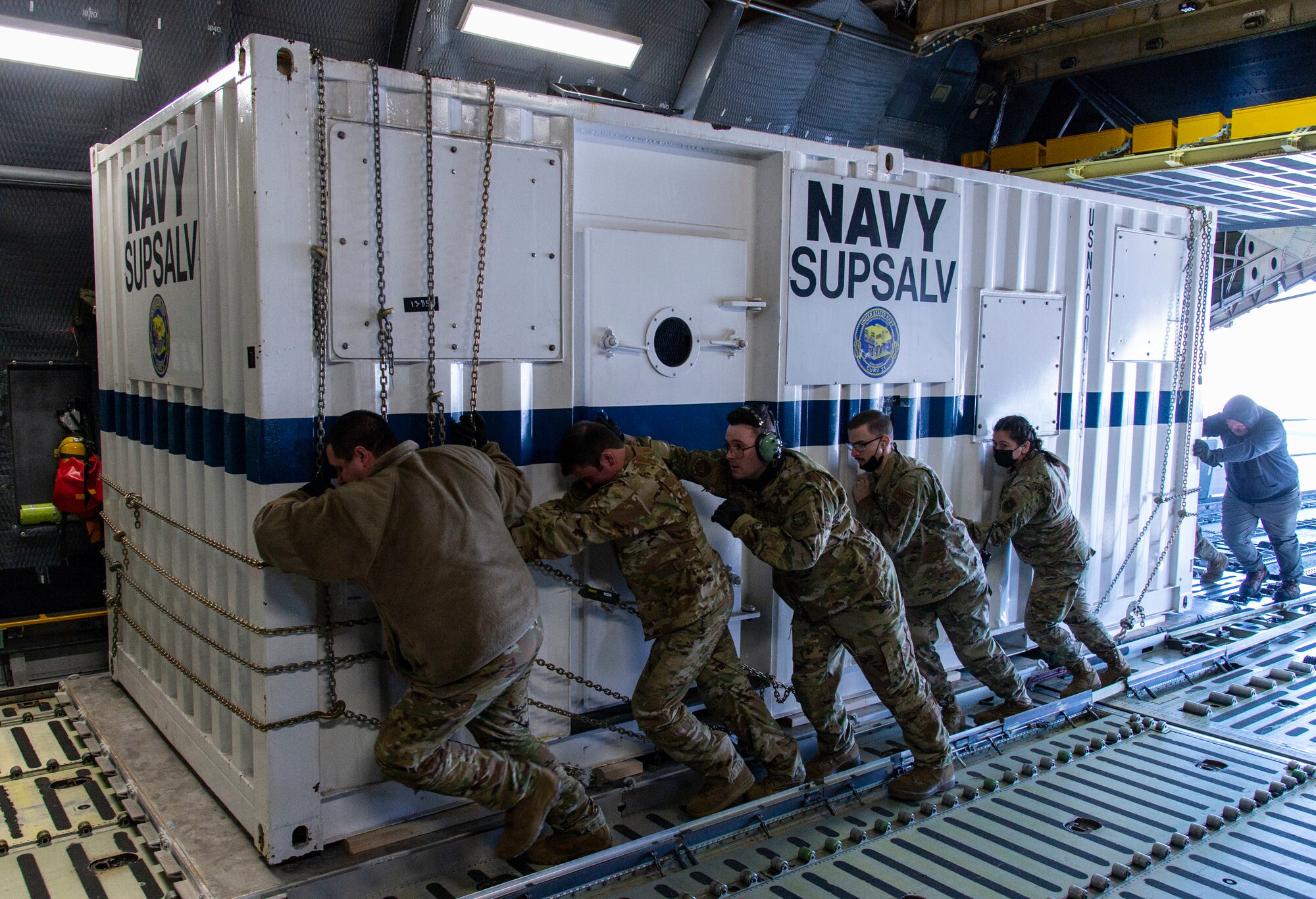 Loadmasters from the 9th Airlift Squadron along with 436th Aerial Port Squadron ramp services personnel, load cargo onto a C-5M Super Galaxy at Dover Air Force Base, Delaware, Feb. 8, 2022. The C-5M transported cargo owned by U.S. Navy Supervisor of Salvage and Diving (SUPSALV), Naval Sea Systems Command. (U.S. Air Force photo by Roland Balik)