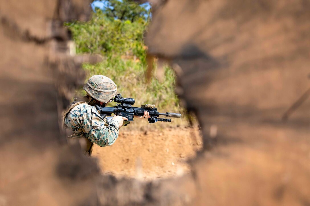 A Marine looks through the scope of a weapon.