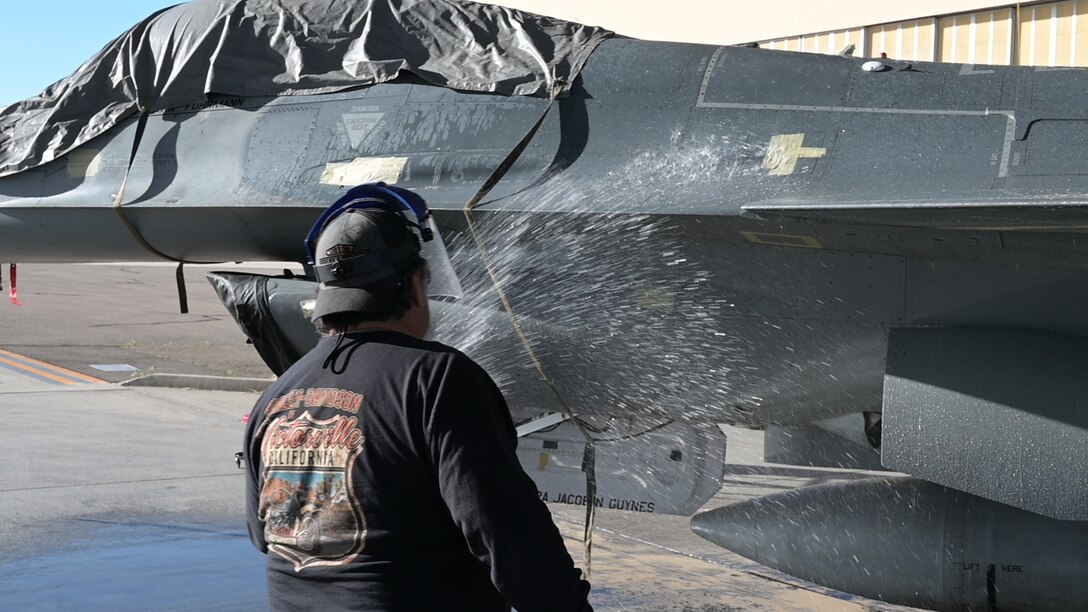 F-16 crew chiefs on Edwards Air Force Base are busy washing the aircraft to prevent corrosion.