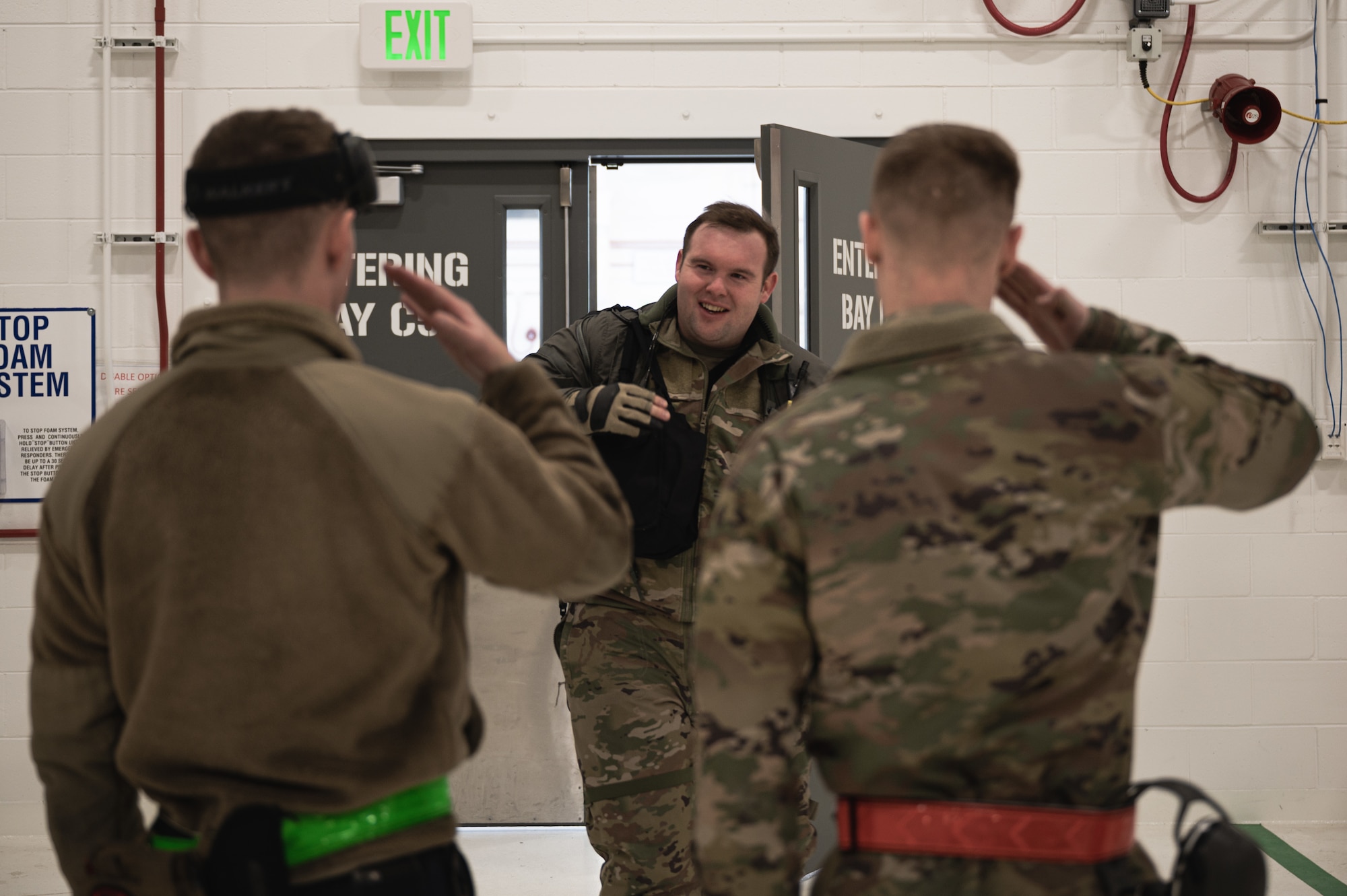 U.S. Air Force Airman 1st Class Ian Sears, a 356th Aircraft Maintenance Unit (AMU) crew chief (left), and Senior Airman Aleksandr Zenski, a 354th Logistics Readiness Squadron vehicle maintenance journeyman (right), salute Capt. Jonathan White, a 356th Fighter Squadron F-35 pilot, during a ‘Crew Chief for a Day’ immersion on Eielson Air Force Base, Alaska, March 15, 2022.