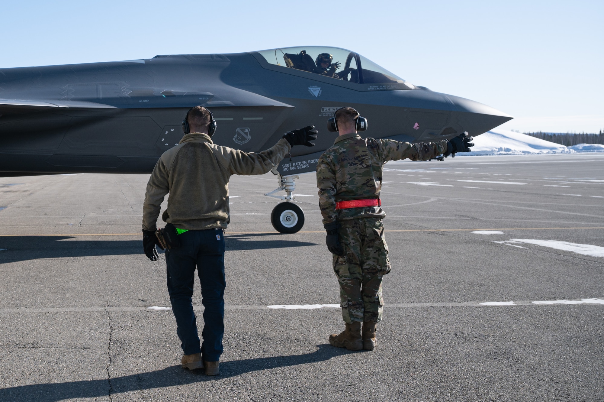 From left, U.S. Air Force Senior Airman Aleksandr Zenski, a 354th Logistics Readiness Squadron vehicle management journeyman; Maj. Jonathan Bucey, a 356th Fighter Squadron F-35 pilot; and Airman 1st Class Ian Spears, a 356th Aircraft Maintenance Unit crew chief, render a squadron salute during a ‘Crew Chief for a Day’ immersion on Eielson Air Force Base, Alaska, March 15, 2022.