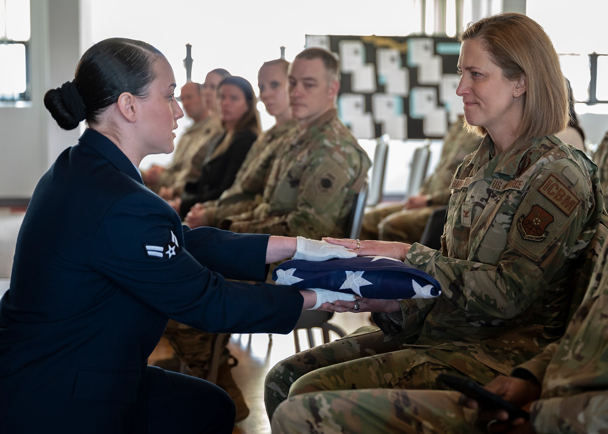 airman hands over ceremonial flag