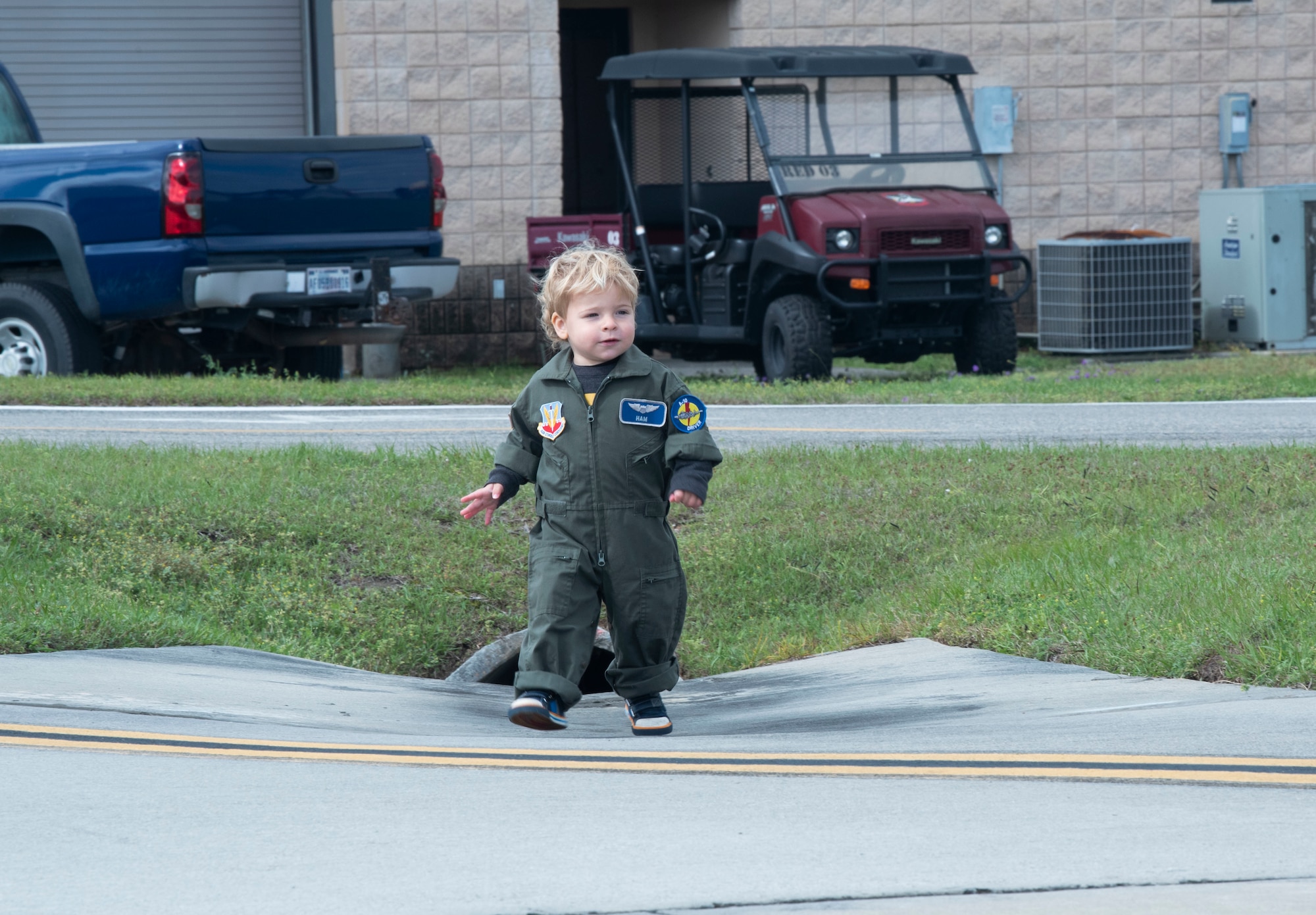 A child explores the flightline in a miniature U.S. Air Force flight suit during the Youth Open House at Moody Air Force Base, Georgia, March 12, 2022. The Youth Open House culminated Women in Aviation and Week allowed a younger generation to connect with Airmen and the Air Force mission in an effort to inspire them for careers in airpower leading to a more diverse and effective Air Force in the future. (U.S. Air Force photo by Senior Airman Thomas Johns)