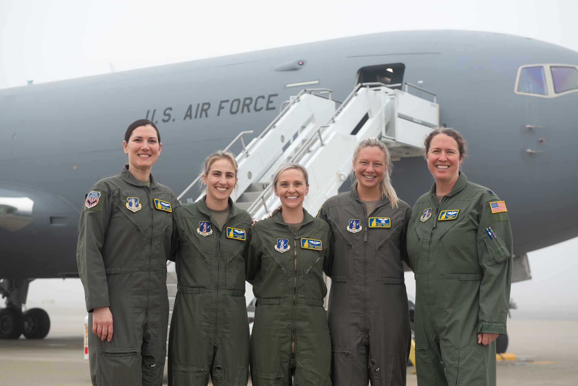 Air crew stand in front of a KC-46 on the Pease flight line.