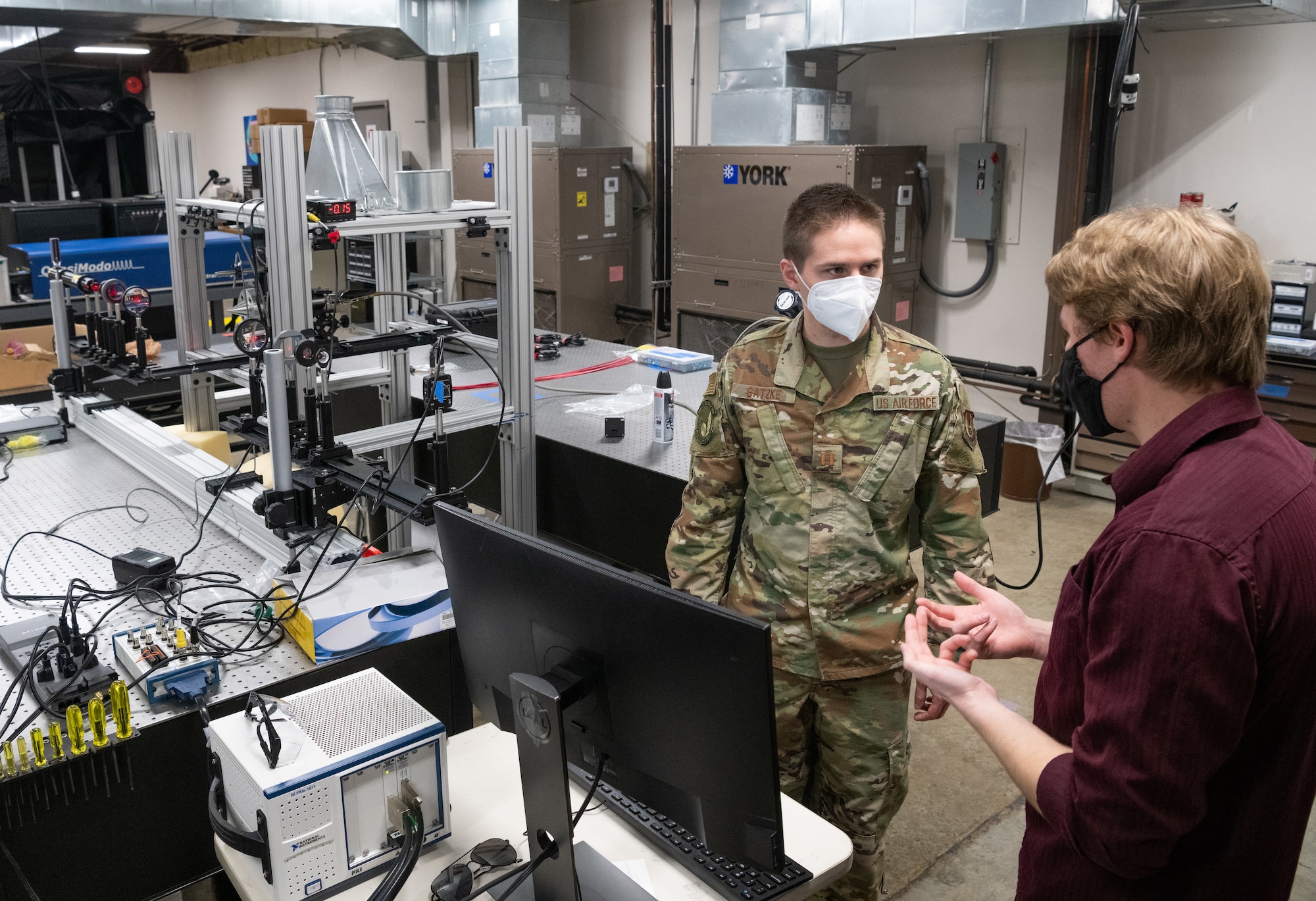 Test engineer Capt. Brian Gatzke with AEDC speaks with Theron Price, of UTSI, about the lab setup in front of them at the University of Tennessee Space Institute.