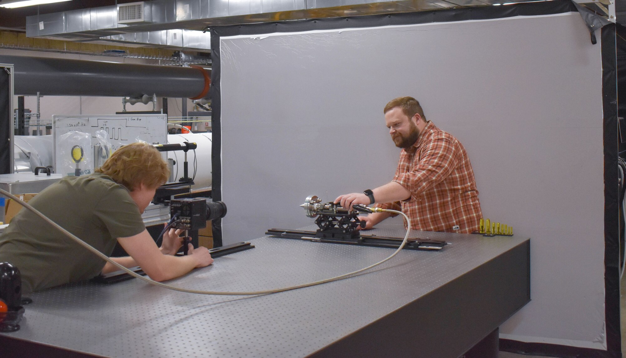 From left, Theron Price and Dr. Phil Kreth, both with UTSI, work with the retroreflective shadowgraph system.