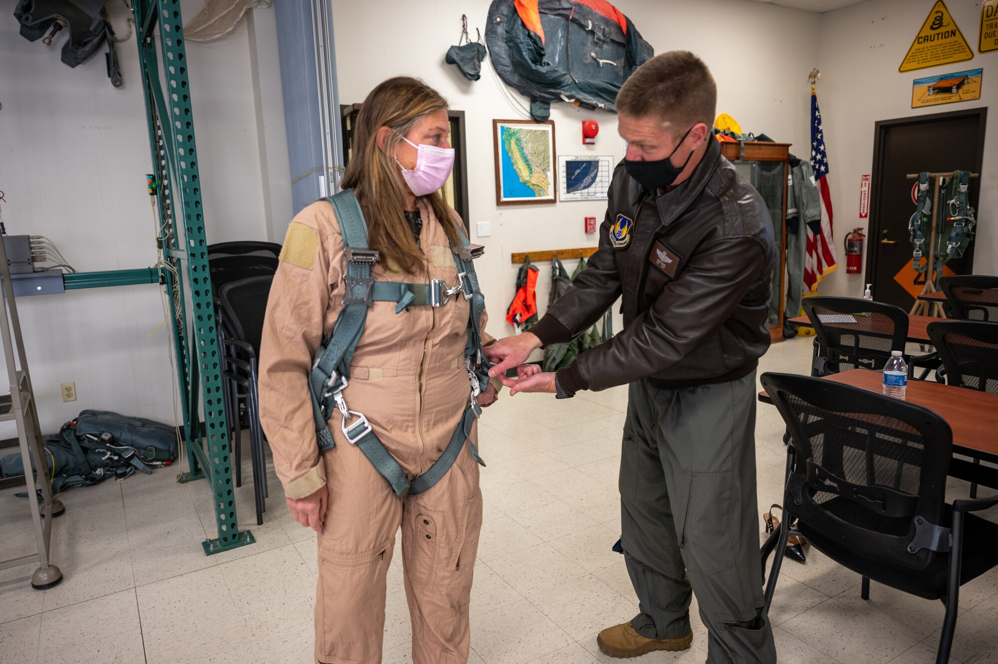 Lt. Col. Joshua Egan, 412th Test Wing Chief of Safety, briefs Laura Macaluso, Director, Department of Defense Force Safety and Occupational Health, on flight safety equipment prior to her orientation flight