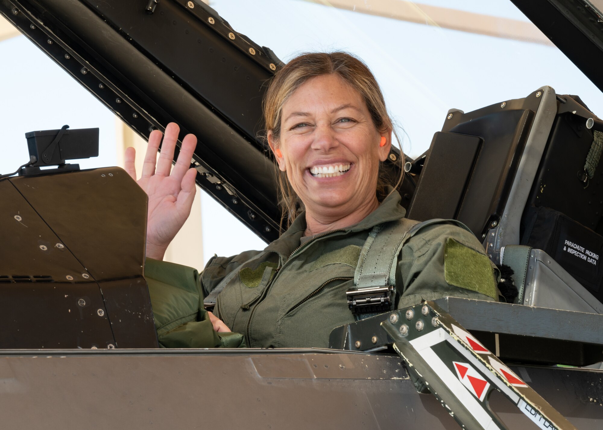 Laura Macaluso, Director, Department of Defense Force Safety and Occupational Health, waves as she prepares for her orientation flight aboard an F-16D Fighting Falcon