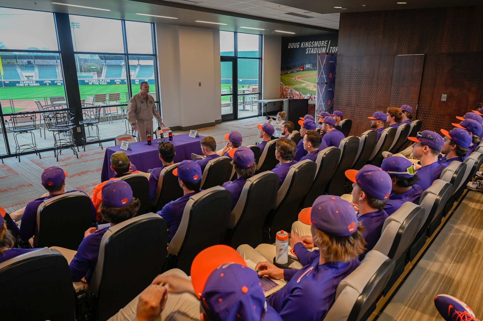 A photo of a general giving a speech to a college baseball team