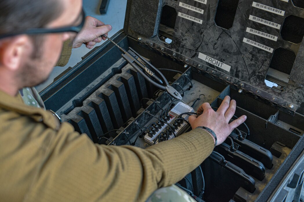 U.S. Air Force Staff Sgt. Brad Clifton, 389th Fighter Generation Squadron support NCOIC, organizes an e-tool charging station during Red Flag-Nellis 22-2 on Nellis Air Force Base, Nevada, March 10, 2022. Technical orders are loaded onto e-tools to be utilized for all aircraft maintenance procedures; ensuring aircraft safety and compliance. (U.S. Air Force photo by Staff Sgt. Austin Siegel)