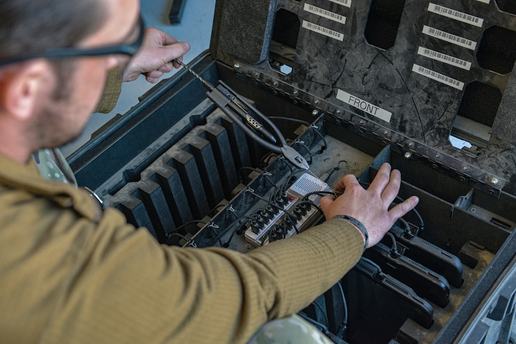 An Airman organizes an e-tool charging station.