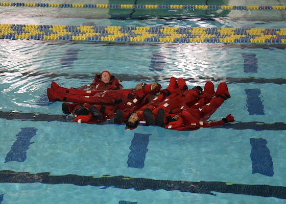 Newly hired Military Sealift Command Civil Service Mariners (CIVMAR) demonstrate the ability to form a floating human life raft during an abandon ship scenario at the Military Sealift Command Training Center East on Joint Base Langley-Fort Eustis, Virginia, Feb. 25.