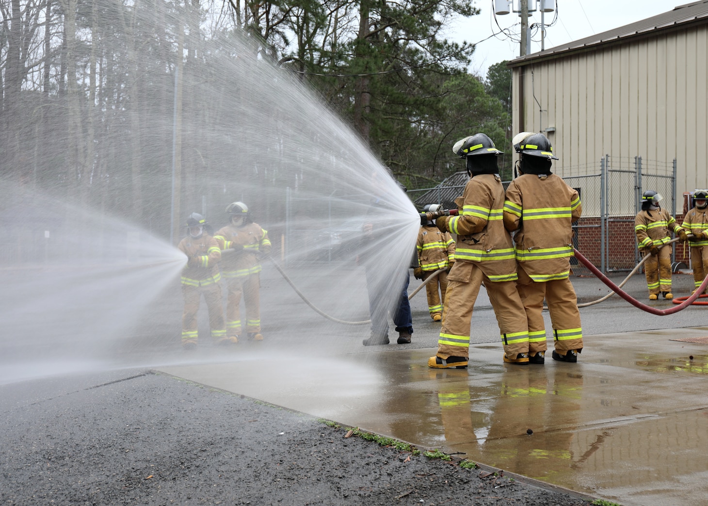 Newly hired Civil Service Mariners (CIVMAR) demonstrate their ability to operate firefighting hoses, at the Military Sealift Command Training Center East on Joint Base Langley-Fort Eustis, Virginia, Feb. 23.