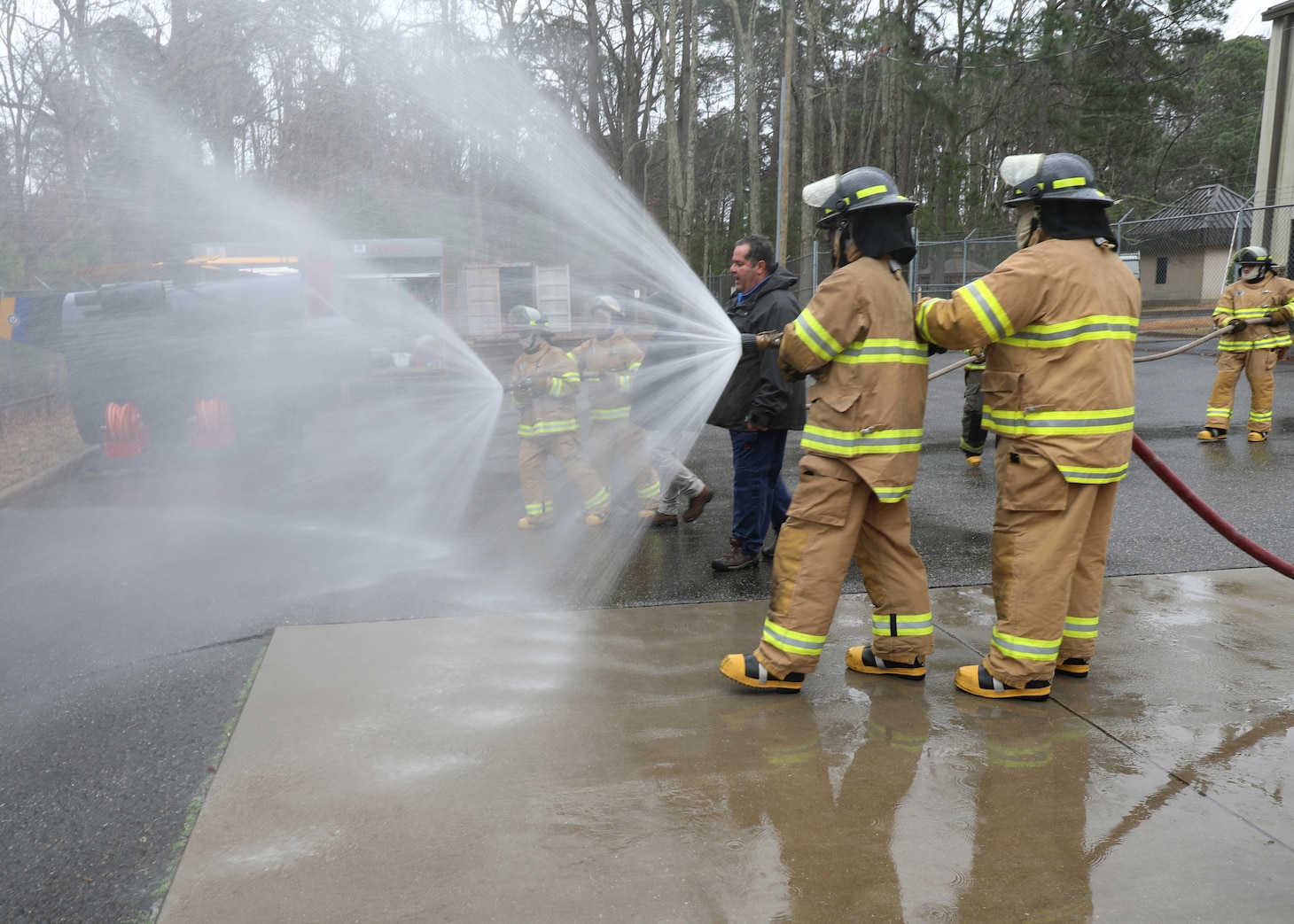 Newly hired Civil Service Mariners (CIVMAR) demonstrate their ability to operate firefighting hoses, at the Military Sealift Command Training Center East on Joint Base Langley-Fort Eustis, Virginia, Feb. 23.