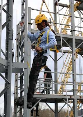 A newly hired Civil Service Mariners (CIVMAR) uses a 'Y' lanyard to transit aloft at the Military Sealift Command Training Center East on Joint Base Langley-Fort Eustis, Virginia, Feb. 22.