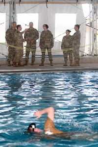 U.S. Army Command Sgt. Maj. JoAnn Naumann, command senior enlisted leader, U.S. Special Operations Command, Korea (center) speaks with U.S. Air Force Master Sgt. Michael Perolio, Special Warfare Training Flight Superintendent, (center left) about the Assessment and Selection process for Air Force Special Warefare candidates at Joint Base San Anotnio, TX, Mar. 16, 2022. Naumann visited the area to mentor the NCOs and observe the SWTW Assessment and Selection process. (U.S. Air Force photo by Brian Boisvert)