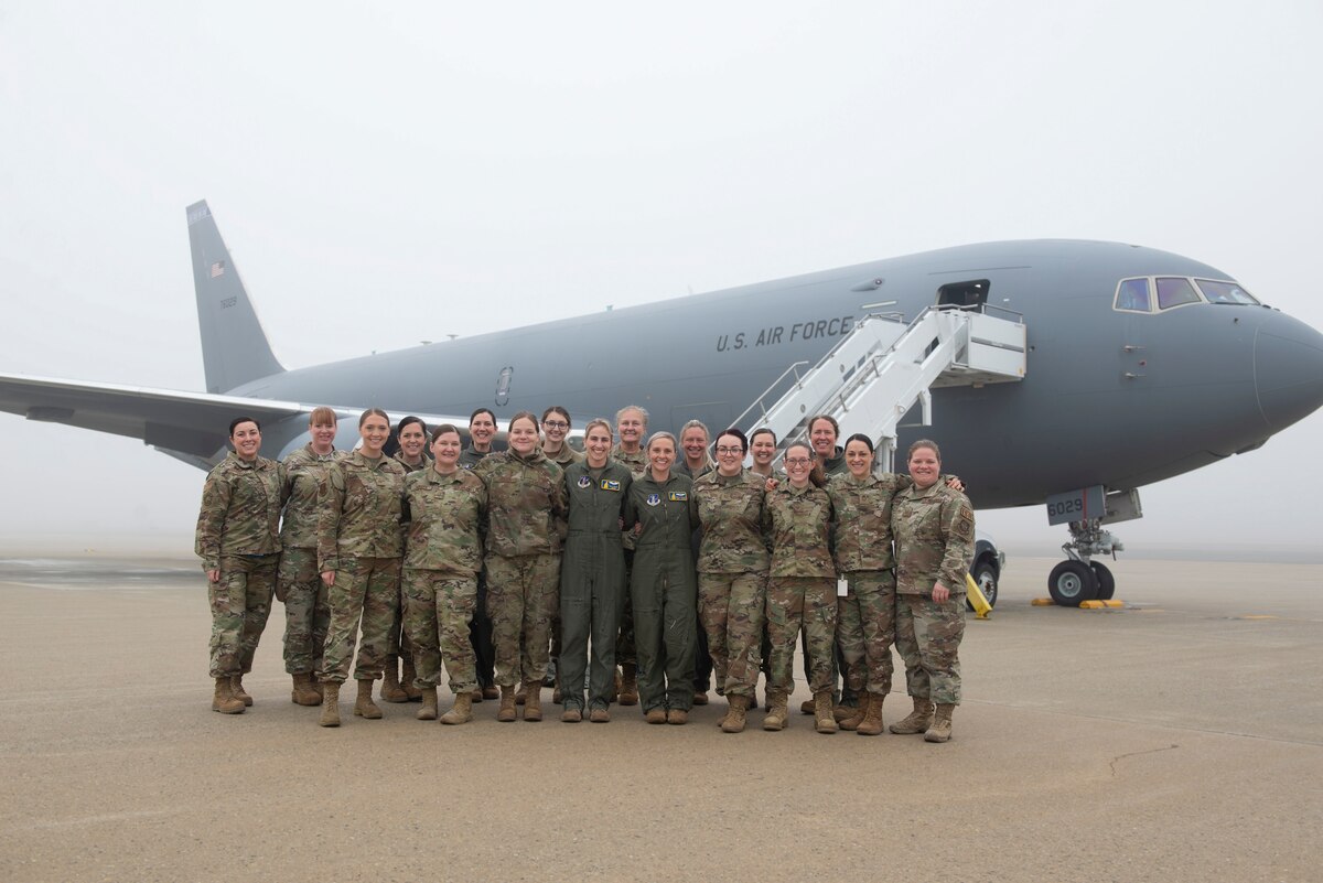 Ground and air crew stand in front of a KC-46 on the Pease flight line.