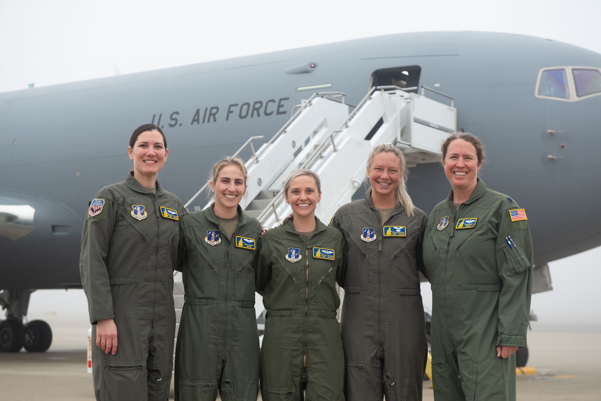 Air crew stand in front of a KC-46 on the Pease flight line.