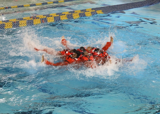 Newly hired Military Sealift Command Civil Service Mariners (CIVMAR) demonstrate a 'sunburst' formation during an abandon ship scenario at the Military Sealift Command Training Center East on Joint Base Langley-Fort Eustis, Virginia, Feb. 25.