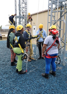 Taylor Pruitt, an instructor a Military Sealift Command Training Center East, demonstrates the use of a 'Y' lanyard, used to transit aloft aboard a ship, at the training facility on Joint Base Langley-Fort Eustis, Virginia, Feb. 22.