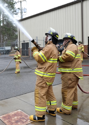 Newly hired Civil Service Mariners (CIVMAR) demonstrate their ability to operate firefighting hoses, at the Military Sealift Command Training Center East on Joint Base Langley-Fort Eustis, Virginia, Feb. 23.