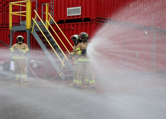 Newly hired Civil Service Mariners (CIVMAR) demonstrate their ability to operate a firefighting hose, at the Military Sealift Command Training Center East on Joint Base Langley-Fort Eustis, Virginia, Feb. 23.