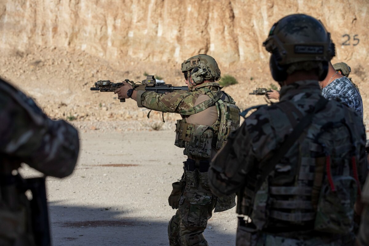 Soldiers shoot weapons.