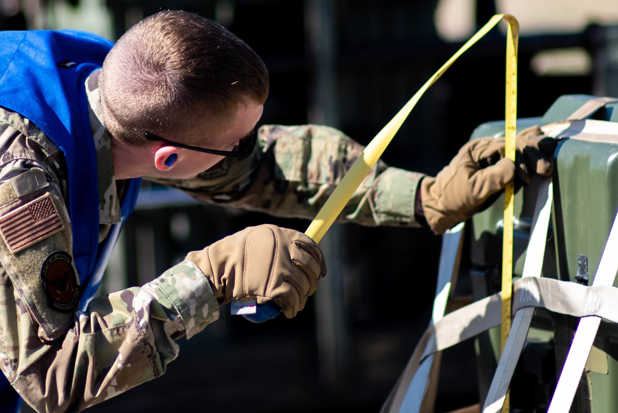 U.S. Air Force Airman 1st Class Phillip Walter, 375th Logistics Readiness Squadron fuels controller, inspects a pallet during a mobility deployment rehearsal, on Scott Air Force Base, Illinois, March 16, 2022.  This deployment mobility rehearsal emphasizes readiness of command and control procedures and continuity of operations in a simulated contested environment. (U.S. Air Force photo by Airman 1st Class Violette Hosack)