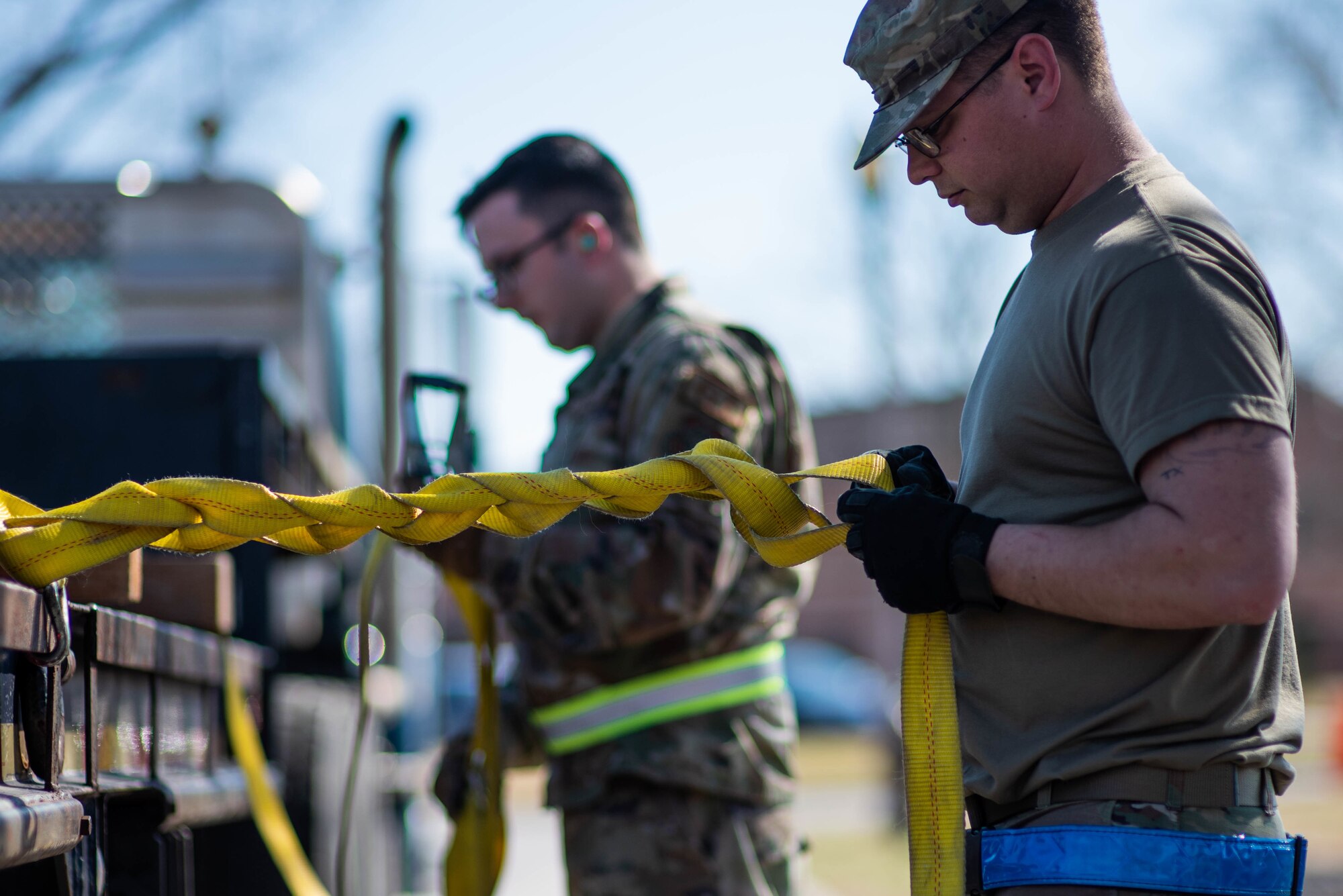 U.S. Air Force Airman 1st Class Corbin Willoughby, 375th Logistics Readiness Squadron ground transportation operator, ratchets a cargo strap on a semitruck on Scott Air Force Base, Illinois, March 16, 2022. Loading cargo for the readiness rehearsal simulated real world operations for 375th LRS ground transportation operators. (U.S. Air Force photo by Airman 1st Class Violette Hosack)