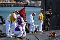 Sailors assigned to the Virginia-class fast-attack submarine USS Minnesota (SSN 783) heave mooring lines as the boat makes its homecoming arrival at Joint Base Pearl Harbor-Hickam.