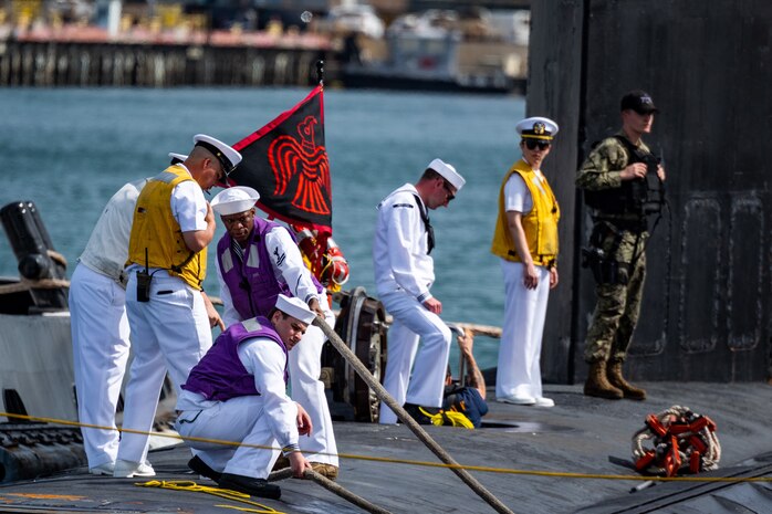 Sailors assigned to the Virginia-class fast-attack submarine USS Minnesota (SSN 783) heave mooring lines as the boat makes its homecoming arrival at Joint Base Pearl Harbor-Hickam.