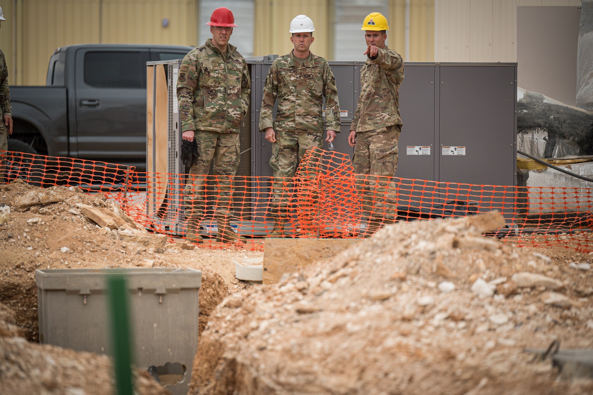 U.S. Air Force Senior Airman Jaren Rutledge, 557th Expeditionary Prime Beef Squadron electrician, describes some of the trench work being done around Red Tail Village with Brig. Gen. Christopher Sage, 332d Air Expeditionary Wing commander, and Chief Master Sgt. Sean Milligan, 332d AEW command chief, at an undisclosed location in Southwest Asia Mar. 12, 2022. (U.S. Air Force photo by Master Sgt. Christopher Parr)
