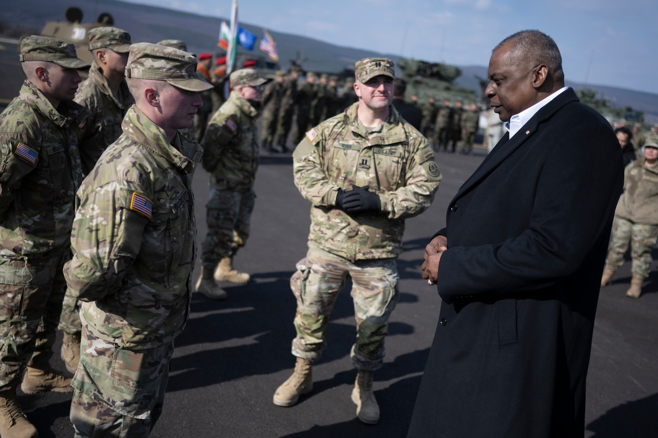 Troops talk to a man.
