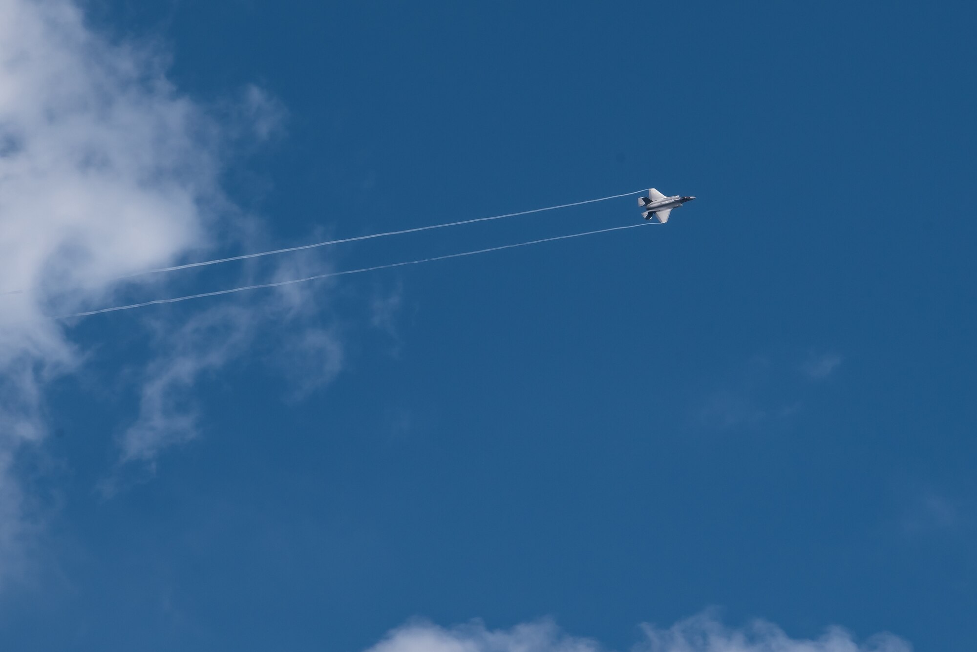 An F-35A Lightning II flies over the flightline at Kadena Air Base, Japan.