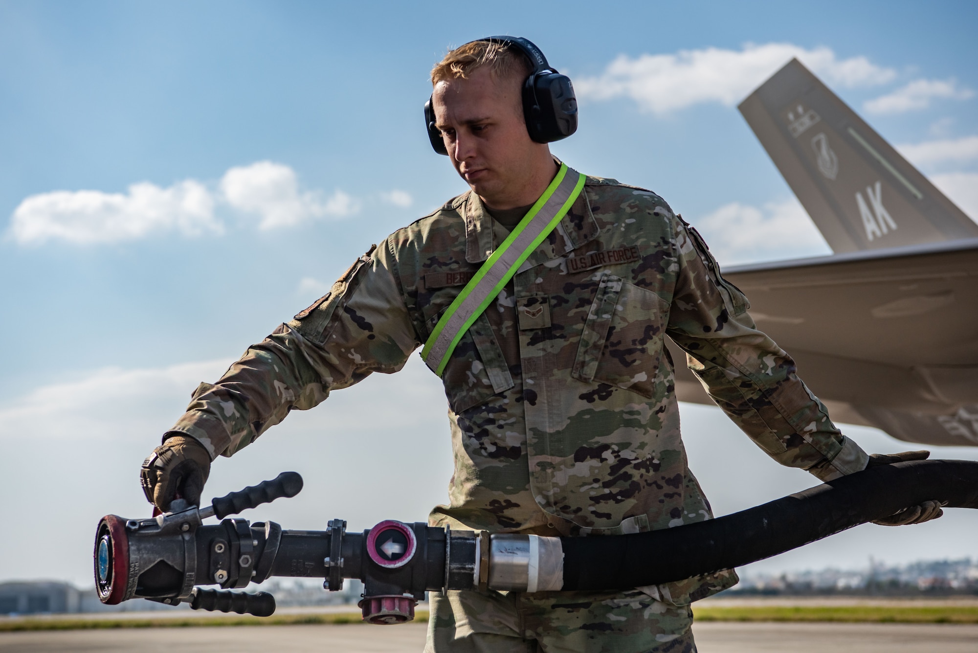 An Airman carries a refueling nozzle.