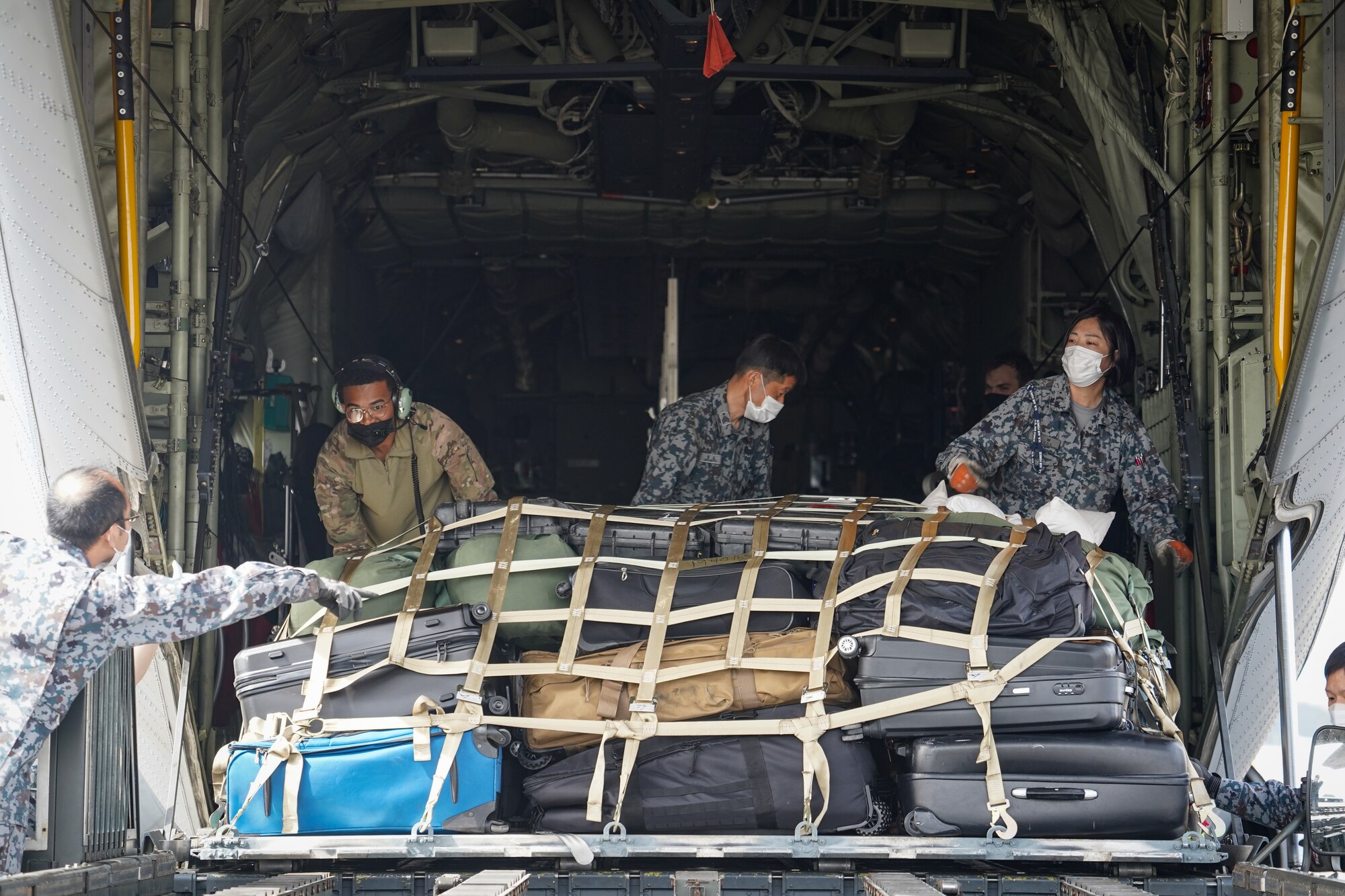 U.S. Air Force Senior Airman Milo Carter, 36th Airlift Squadron loadmaster, works with Japan Air Self-Defense Force members to unload a U.S. Air Force C-130J Super Hercules assigned to the 36th Airlift Squadron, Yokota Air Base, Japan on the JASDF Tsuiki Air Base flightline, March 17, 2022. Tsuiki Air Base is hosting the current iteration of the aviation training relocation program which increases operational readiness and improves interoperability with our Japanese allies. (U.S. Air Force photo by Staff Sgt. Kyle Johnson)
