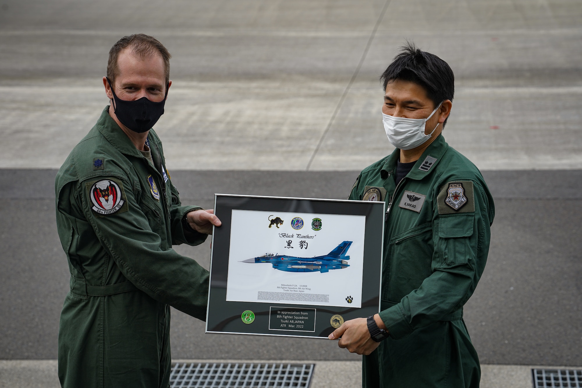 U.S. Air Force Lt. Col. William "Wild" Strohecker, 44th Fighter Squadron commander (left), accepts a gift from Japan Air Self-Defense Force Lt. Col. Kenji Nakao, 8th Fighter Squadron commander (right), at a press conference on Tsuiki Air Base, Fukuoka, Japan, March 17, 2022. Tsuiki Air Base is hosting the current iteration of the aviation training relocation program, which increases operational readiness and improves interoperability with our Japanese allies. (U.S. Air Force photo by Staff Sgt. Kyle Johnson)